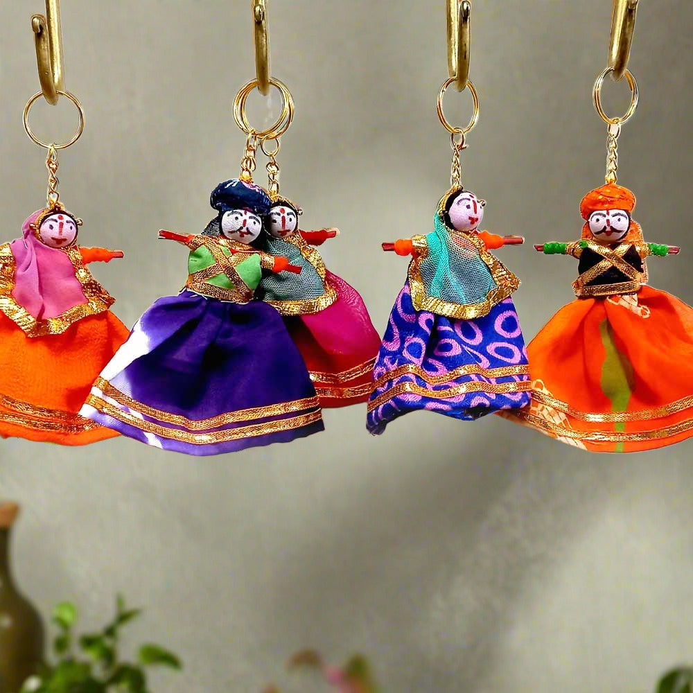 A colorful puppet key chain featuring a couple in a traditional turban and veil.