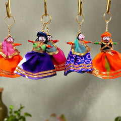 A colorful puppet key chain featuring a couple in a traditional turban and veil.