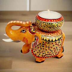 Colorful wooden elephant candle holder painted in gold, red, blue, and black, perfect as a decorative piece.