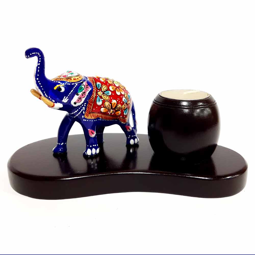 A decorative high-trunk elephant sculpture with a beautiful candle stand on its side.