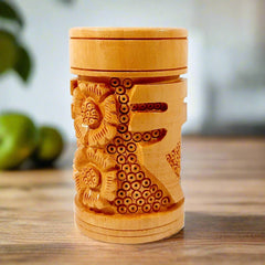 A round wooden desk organizer with a perfectly engraved Indian rupee sign.