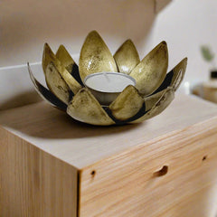Festive metal candle stand with lotus bloom design in golden oxidized finish, adding charm during celebrations.
