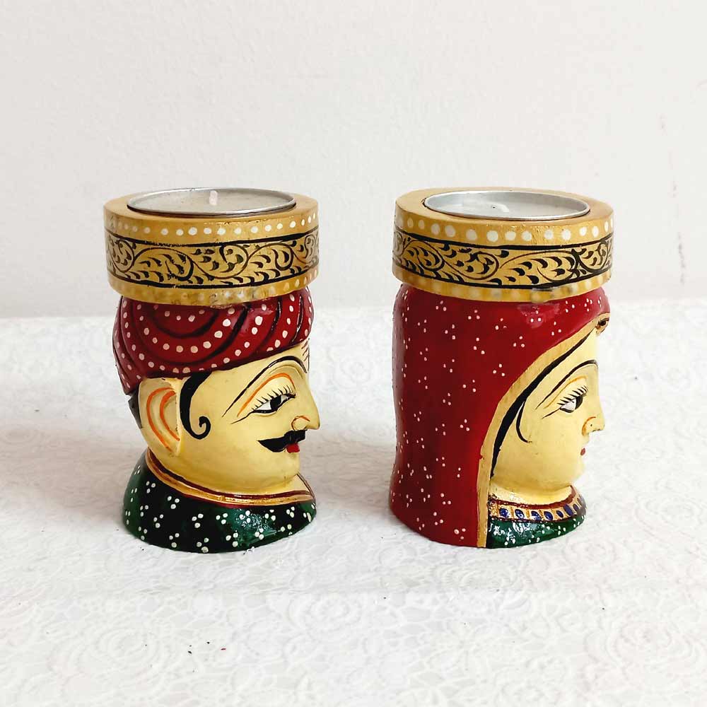 Folk art inspired wooden candle stand with man and woman faces, perfect for festive and home decor.