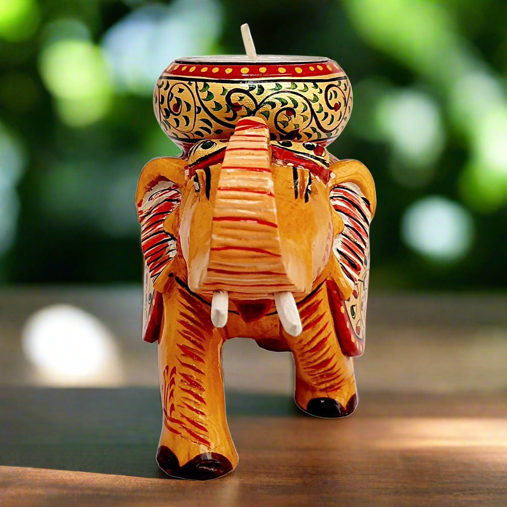Folk art style wooden elephant candle holder featuring bright hand-painted details and a functional round candle stand.