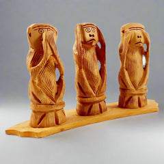 Hand carved wooden monkey covering ears, hear no evil from Gandhi set.