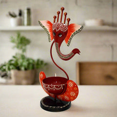 Lord Ganesh metal tealight holder with divine glow for home décor.