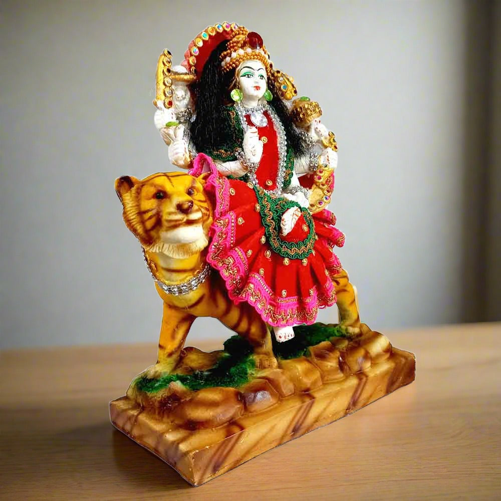 Side view of Goddess Durga statue sitting on a lion with closed mouth.