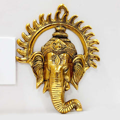 A golden metal sun Ganesha face, a unique and beautiful wall art piece.