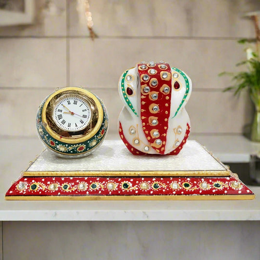 A hand-painted marble desk clock with a Ganesha idol and a round ball clock, using red, green, and gold colors.