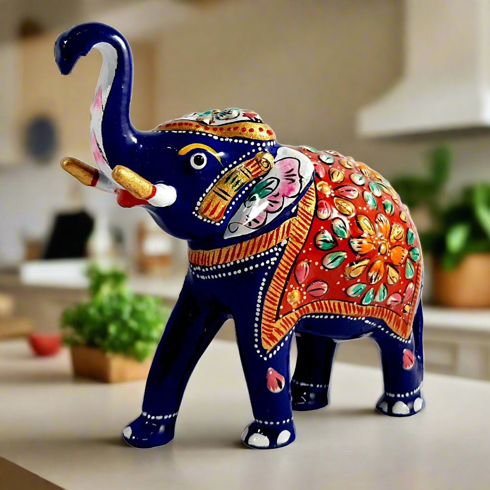 A hand-painted blue Meenakari elephant figurine with a multicolored back cushion.