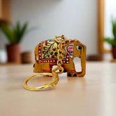 A cute, hand-painted wooden elephant keychain with beautiful golden, red, and green colors.