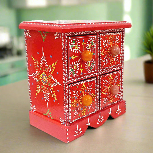 A beautiful hand-painted wooden jewelry box with 4 drawers and vibrant colors.
