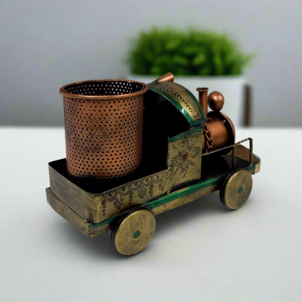 Handcrafted metal train pen holder with antique finish and intricate handmade painting, a stylish office accessory.