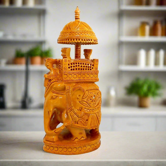 A handcrafted wooden Ambadi elephant statue with a king on a throne under a canopy.
