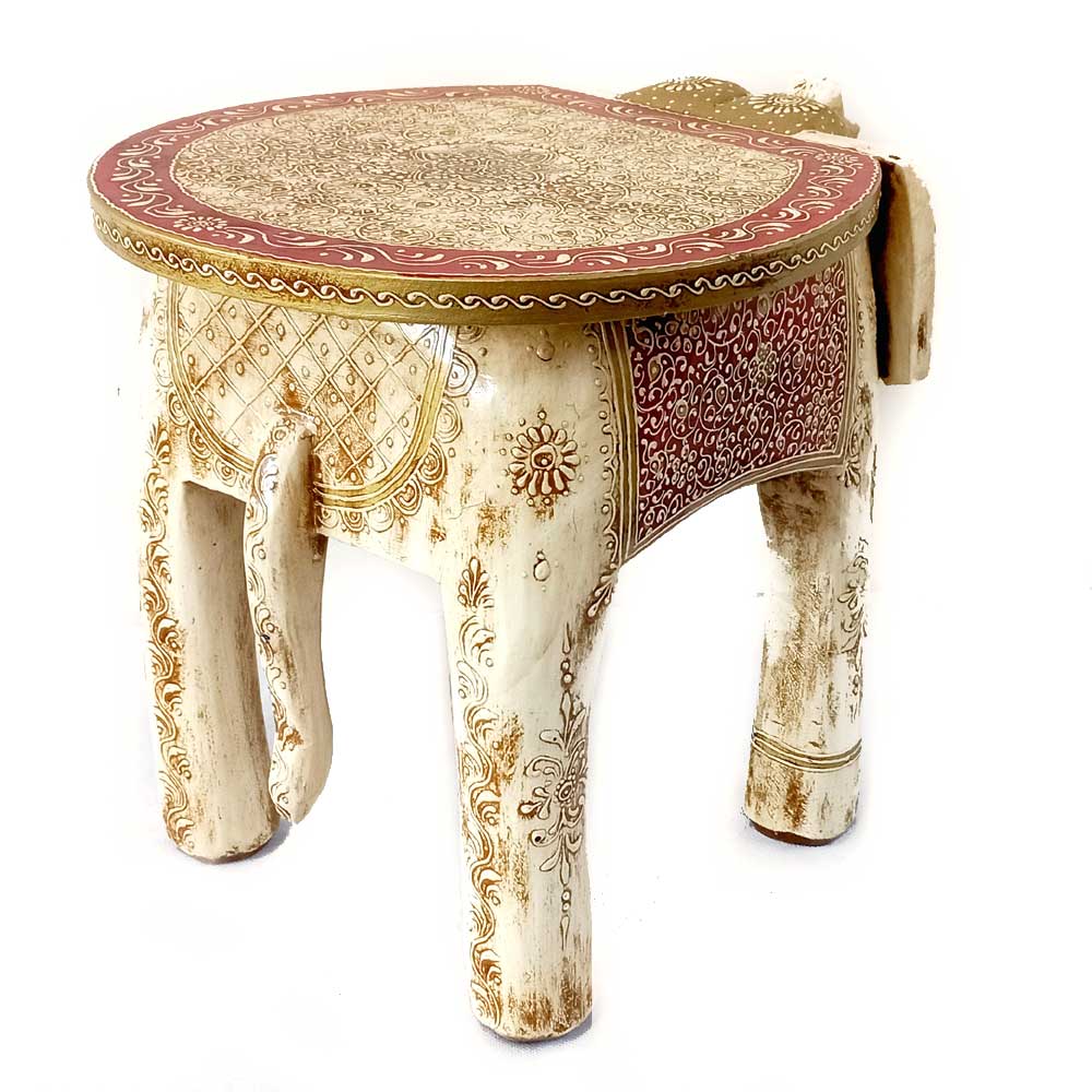 A handcrafted wooden elephant accent stool with beautiful ivory color and fine carving.