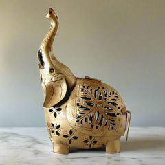 A handmade metal elephant candle holder with a high trunk and a modern design.