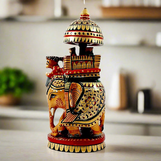 A beautiful handmade wooden Ambabari elephant idol decorated with hand painting in gold, red, and green colors.