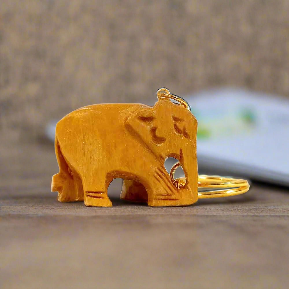 A small handcrafted wooden elephant keychain with fine wood carving artistry.