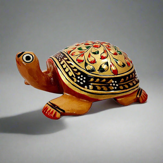 A handmade wooden Vastu tortoise with beautiful golden emboss painting, perfect for home and office.