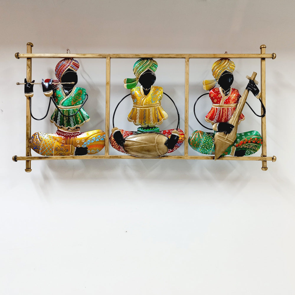 Hand-painted metal wall frame depicting Rajasthani magician musicians performing with traditional instruments.