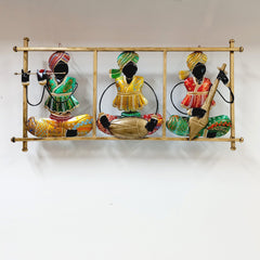 Hand-painted metal wall frame depicting Rajasthani magician musicians performing with traditional instruments.