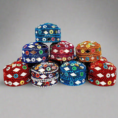 A stunning kumkum box decorated with vibrant Jaipuri lac work, pearls, and stones.