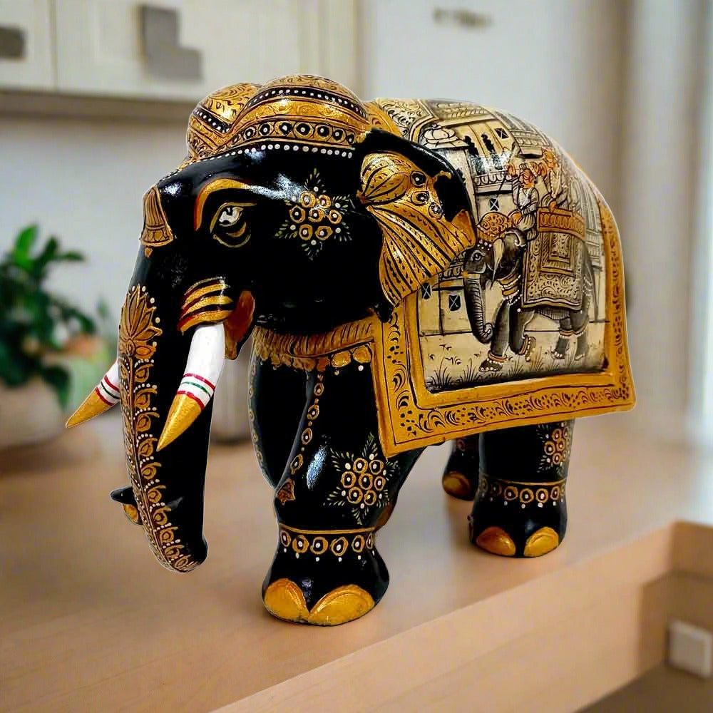 Kadamba wood elephant statue decorated with miniature paintings on both sides, featuring black body, gold painting, and white wooden teeth.