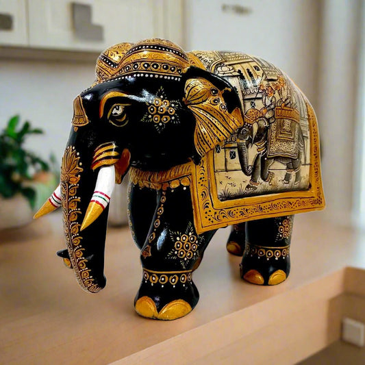 Kadamba wood elephant statue decorated with miniature paintings on both sides, featuring black body, gold painting, and white wooden teeth.