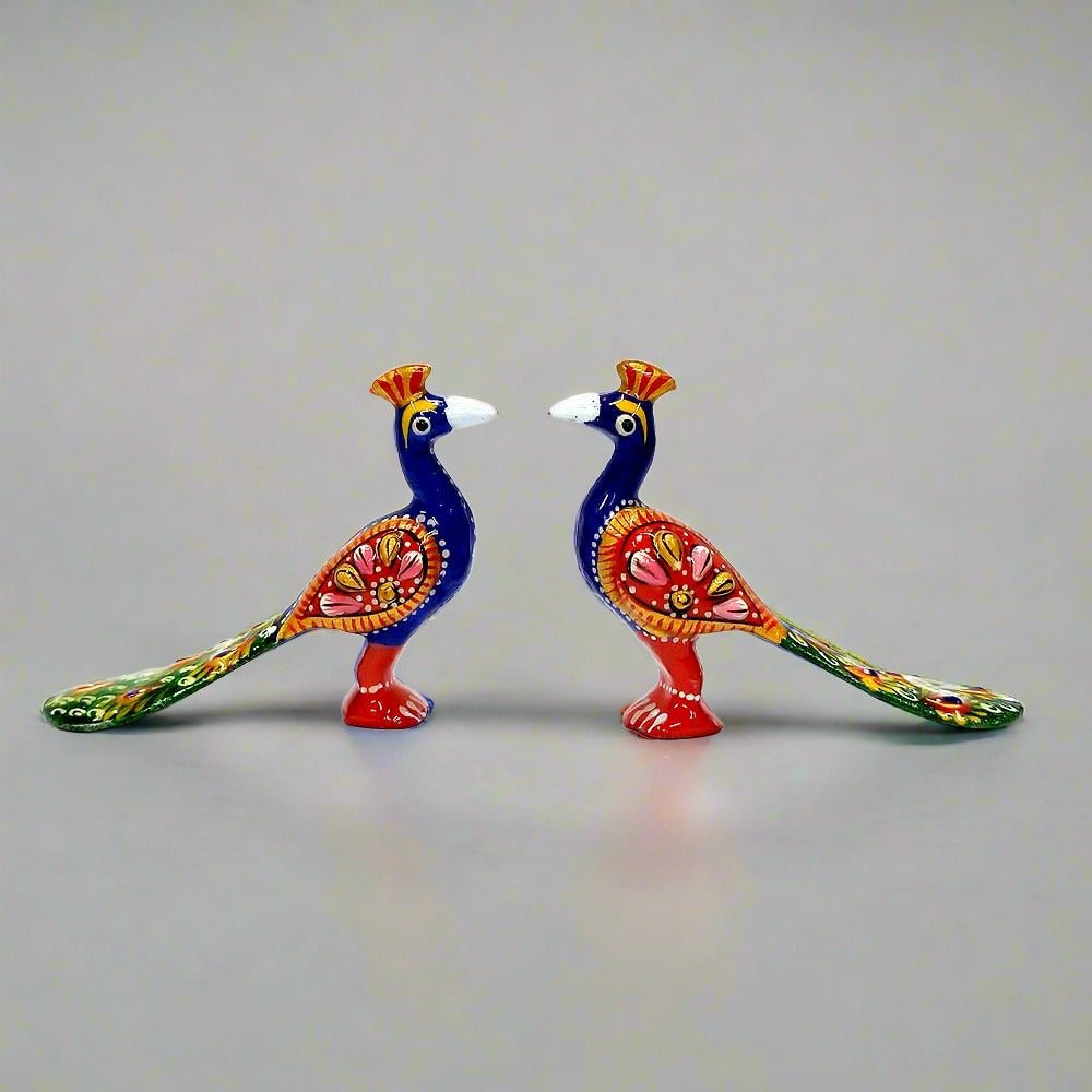 A metal Laddu Gopal toy set with meenakari hand painting, including an elephant and a peacock.