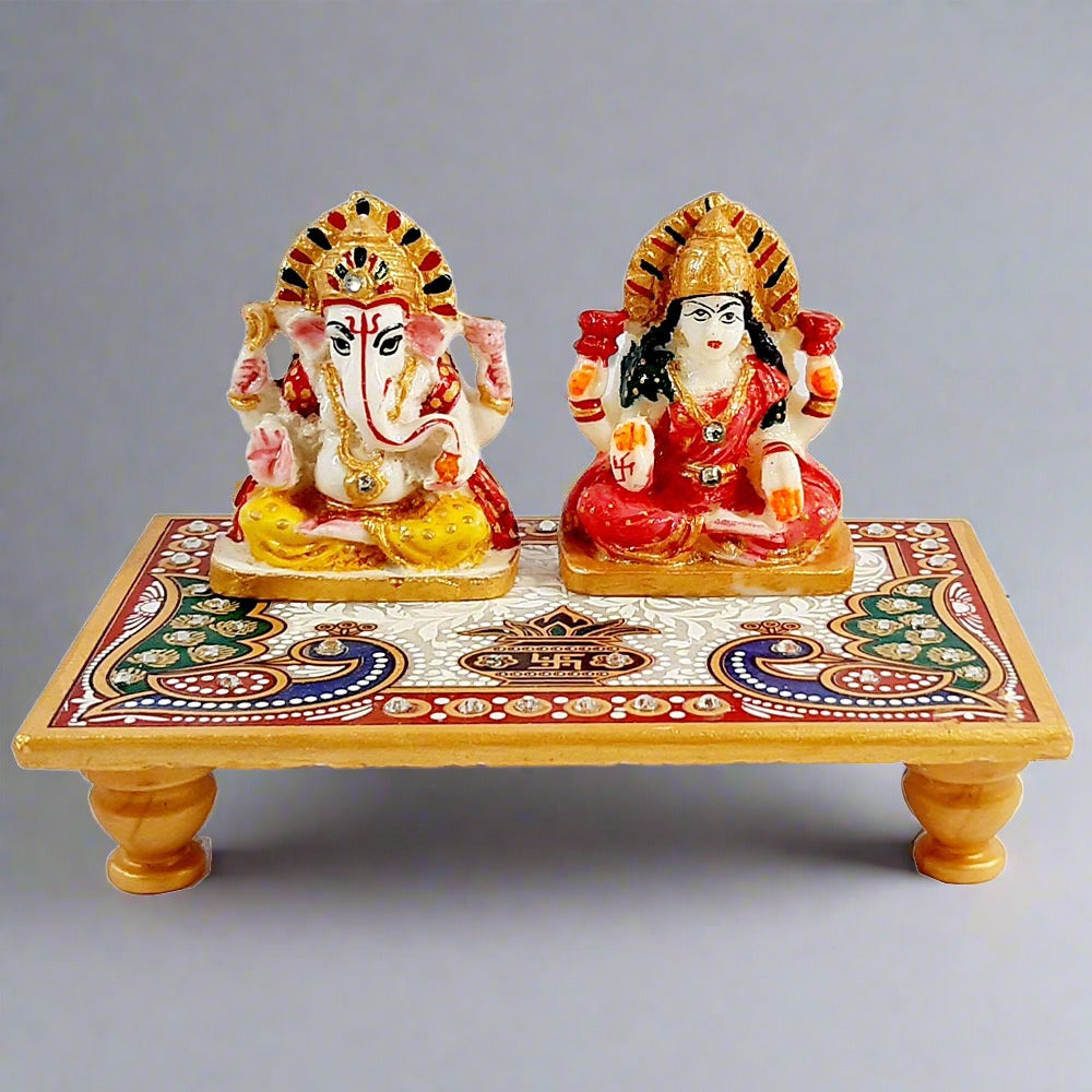A beautiful marble idol of Lakshmi and Ganesh seated on a chowki with a hand-painted peacock design.