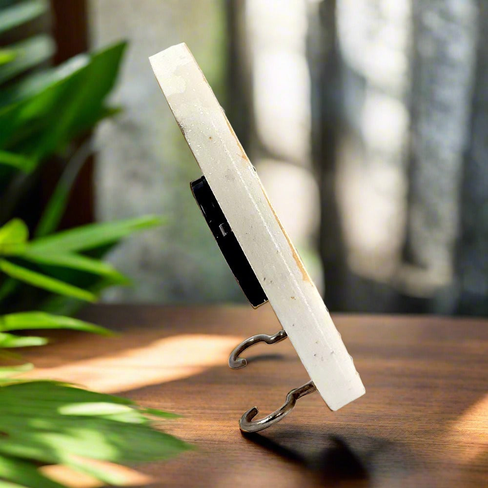 Side angle of pure marble peacock clock with colorful kundan embellishments.