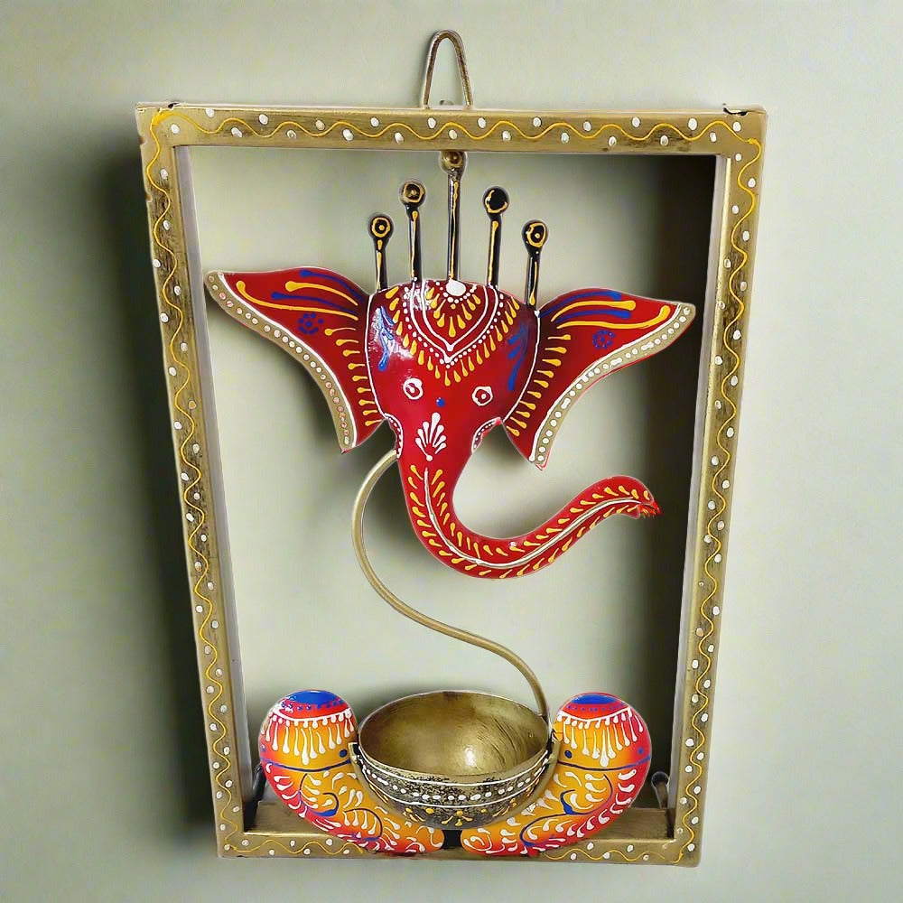 A Ganesha idol inside a metal frame, featuring a tealight holder at the base.