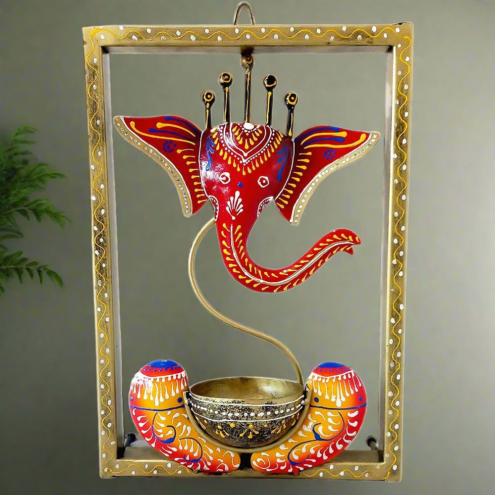 A hand-painted metal Ganesha wall hanging with a tealight candle holder.