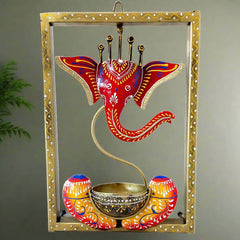 A hand-painted metal Ganesha wall hanging with a tealight candle holder.