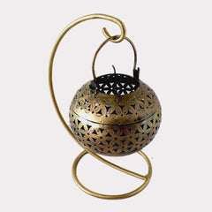 A golden metal mesh candle holder, a perfect centerpiece for a table.