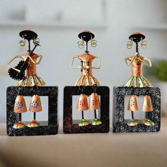 A set of 3 metal musical dolls sitting on a wooden plank, a beautiful showpiece.