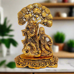 Metal Radha Krishna idol with golden oxidised polish, depicting Radha and Krishna sitting under a tree