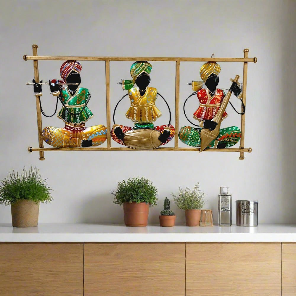 Rajasthani magician musician metal wall hanging frame featuring three men playing tabla, flute, and veena with colorful hand painting.