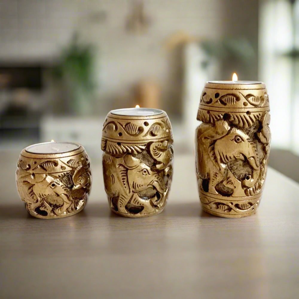 A set of 3 wooden t-light holders with intricate carving.