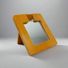 A square-shaped wooden hand mirror with an elephant design.