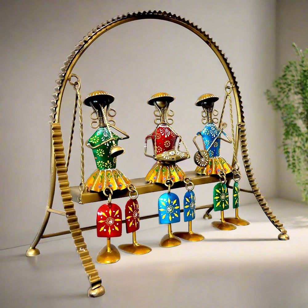 A stunning home decor doll set with three dolls sitting on a metal swing that actually moves.