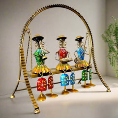 A stunning home decor doll set with three dolls sitting on a metal swing that actually moves.