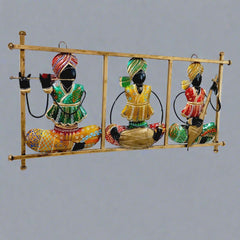 Traditional Rajasthani metal wall art showing magician musicians playing instruments, decorated with vibrant hand painting.