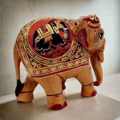 A traditional wood elephant statue with embossed painting on both sides.