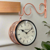 A vintage double-sided metal wall clock with classic engravings, perfect for home decor.