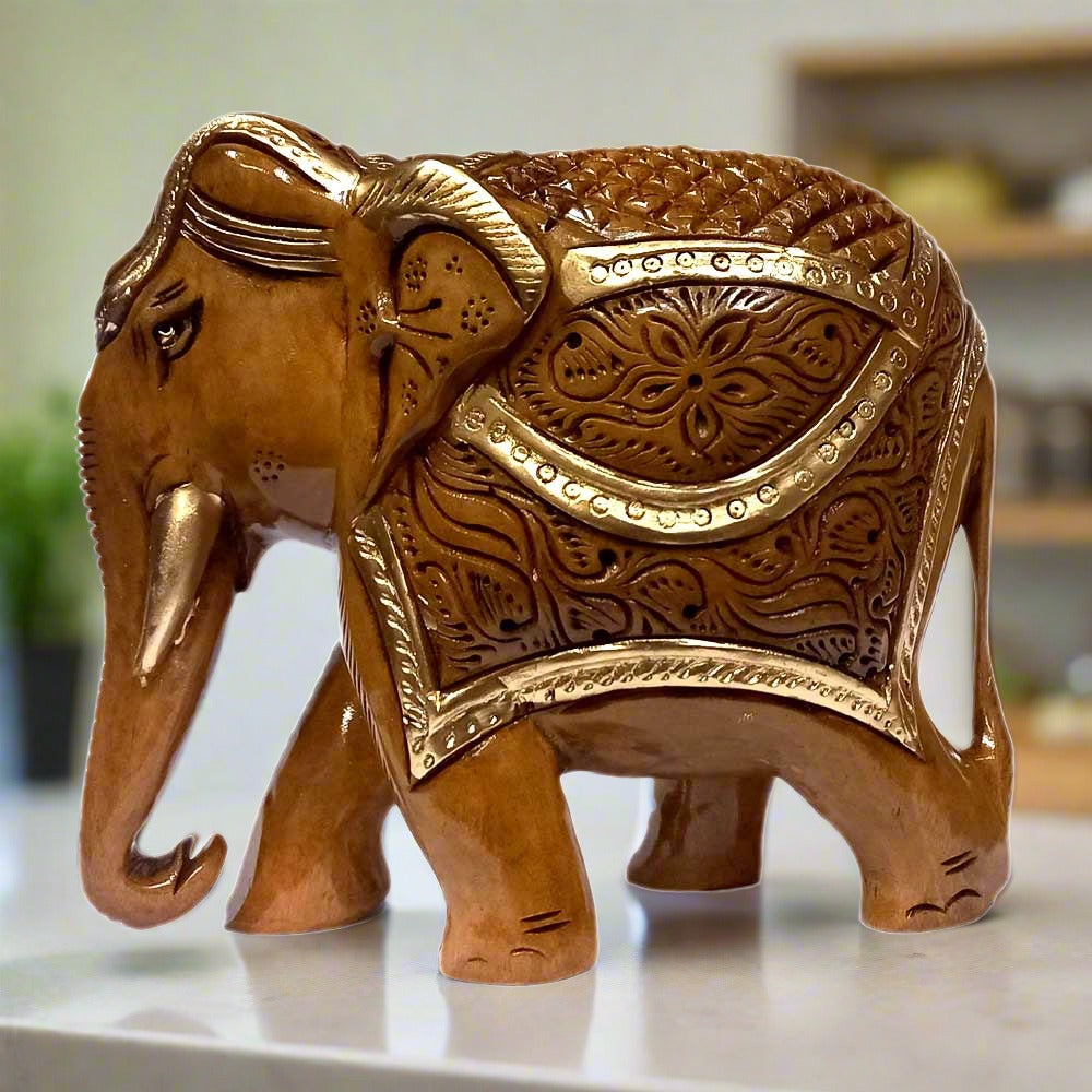 A beautiful wooden carved elephant with a downward-facing trunk and intricate carvings.