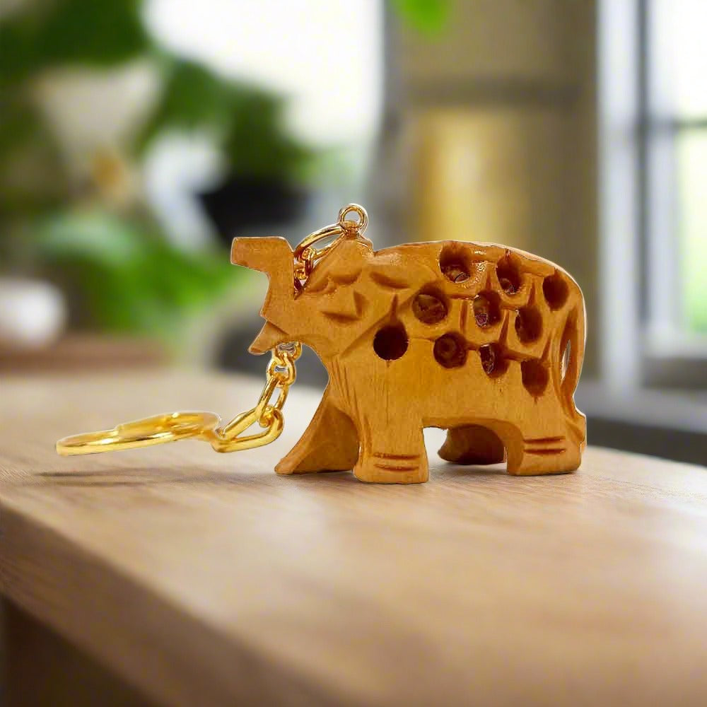 A small wooden elephant key ring with an intricate lattice (undercut) design and a golden polish.