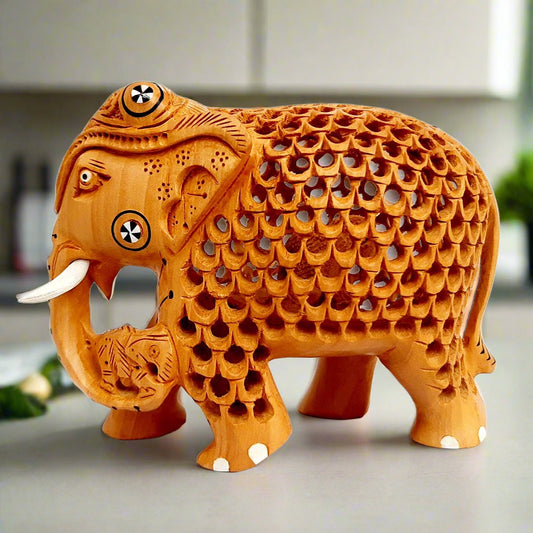 Wooden elephant statue with lattice design and fine carving, carrying a child in trunk, ideal for home decor and gifting