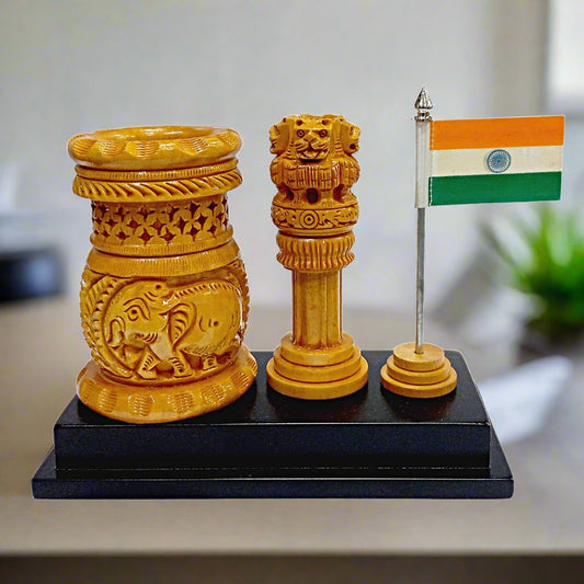 A handmade wooden pen stand featuring a carved Ashoka Pillar and National Flag, perfect for an office desk.