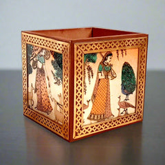 A handmade wooden pen stand decorated with a gemstone painting of a lady and a pure brass border.